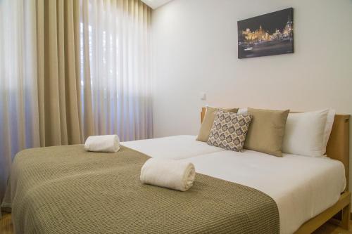 מיטה או מיטות בחדר ב-Spot Apartments Trindade