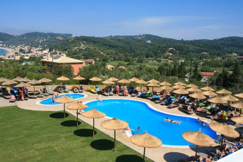 an aerial view of a resort swimming pool with umbrellas at Saint George Palace in Perlopsimades