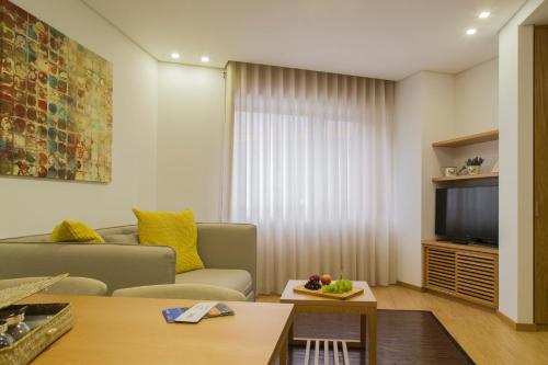 a living room with a couch and a television at Spot Apartments Trindade in Porto