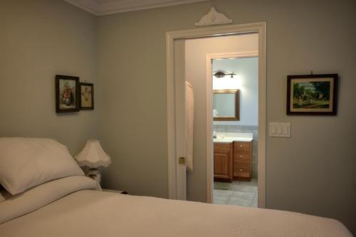 a bedroom with a bed and a bathroom with a sink at Hummingbird Bed and Breakfast in Clearwater