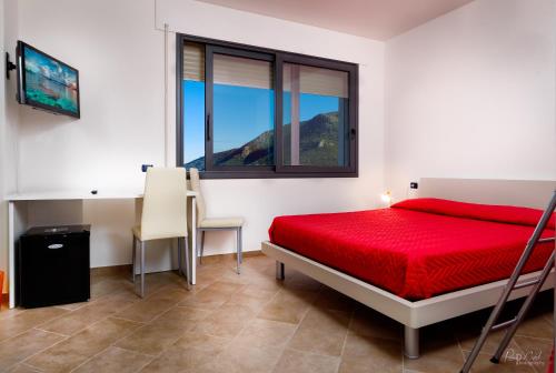 1 dormitorio con cama roja y ventana en Su AlevraXi, en Villagrande Strisaili