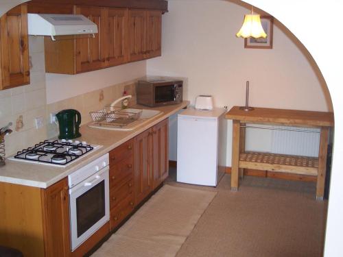 a kitchen with a stove top oven next to a microwave at The Poldark Inn in Delabole