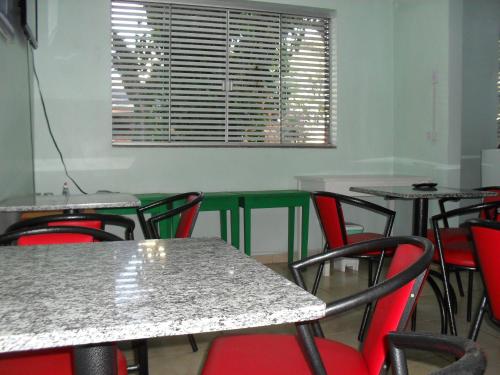 a room with tables and chairs and a window at Hotel Niteroi in Cascavel