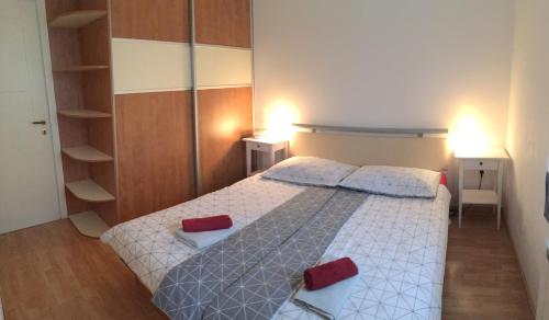 ein Schlafzimmer mit einem Bett mit zwei roten Kissen in der Unterkunft Apartment Nova Gorica - Nočitve Falco in Nova Gorica