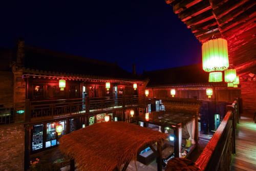 a patio with a table and lights at night at Elsewhere Hotel The former residence of the draft bank in Pingyao