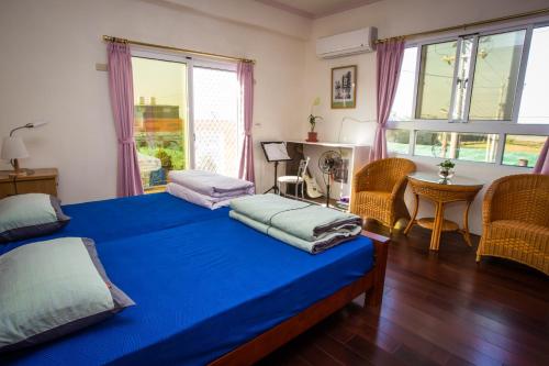 a bedroom with two beds with blue sheets and a table at manor in Houli