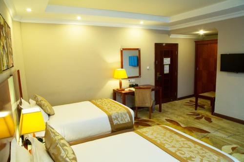 a hotel room with a bed and a television at Jupiter International Hotel - Bole in Addis Ababa