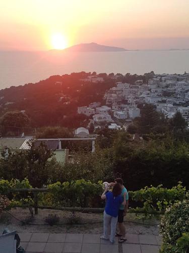 two people taking a picture of the sunset at Agriturismo del Sole in Anacapri