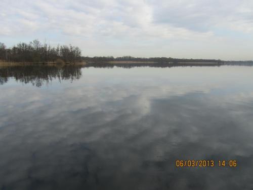 a large body of water with trees in the background at Bed & Breakfast Kortenhoefsedijk in Kortenhoef