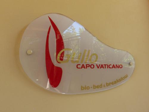 a sign on a wall with a pair of red shoes at Gullo Capo Vaticano in Ricadi
