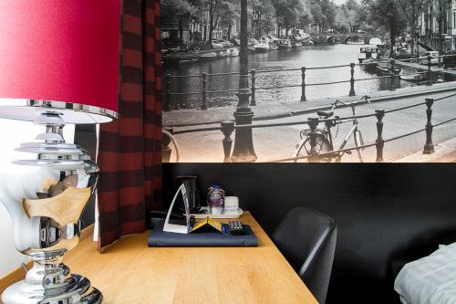 d'un bureau avec une lampe et une photo d'une rivière. dans l'établissement Bastion Hotel Utrecht, à Utrecht