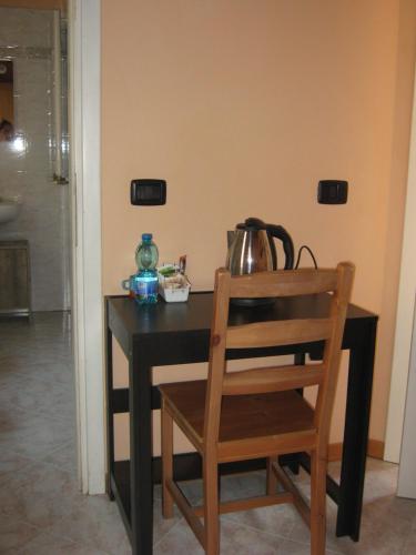 a table with a tea pot and a wooden chair at Albergo Sangalli in Boario Terme