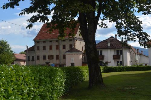 a large building with a tree in front of it at Alla Posta Guest House in Garna dʼAlpago