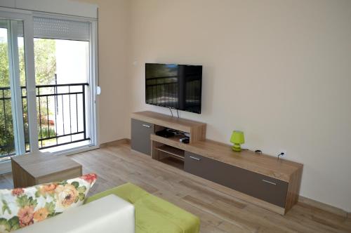 a living room with a flat screen tv on a wall at Apartments MM in Sveti Stefan