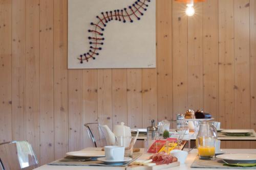 a dining room with a table with food and a picture on the wall at Agritur Casteller in Trento