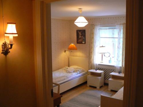 a small bedroom with a bed and a window at Garvaregården Hotel , B&B och Café in Askersund