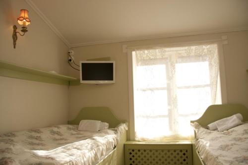 a bedroom with two twin beds and a window at Garvaregården Hotel , B&B och Café in Askersund
