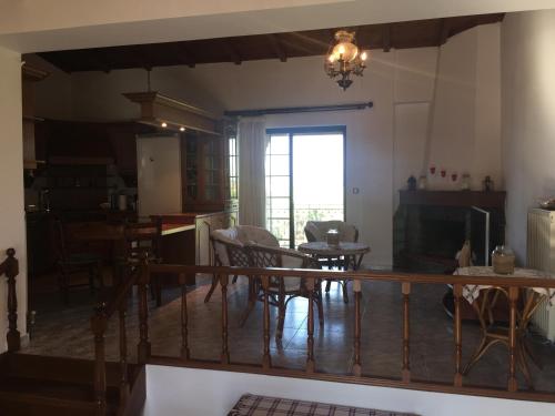 a living room with a table and chairs and a window at Koutrakis House in Iliopoulaíika