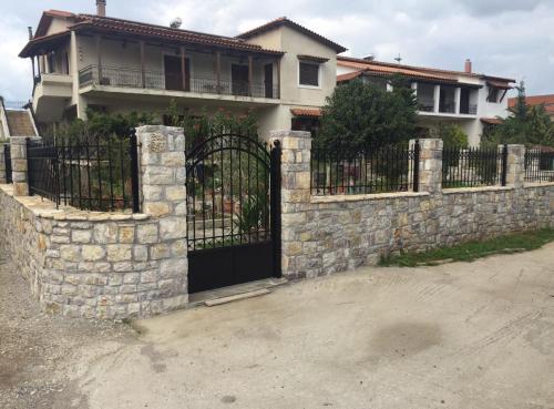 a stone fence with a gate in front of a house at Koutrakis House in Iliopoulaíika