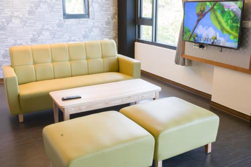 a waiting room with a couch and a table and a tv at Whitecaps B&B in Yanliau