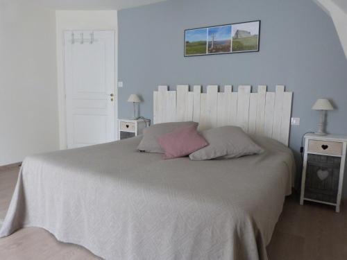 a bedroom with a large white bed with two night stands at La Reine des prés Chambres d'Hôtes in Saint-Bonnet-de-Chirac