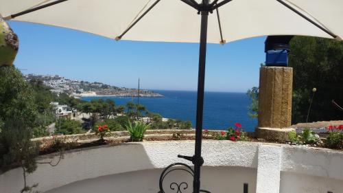 a white umbrella sitting on a balcony with the ocean at La Terrazza on Acquaviva in Marittima