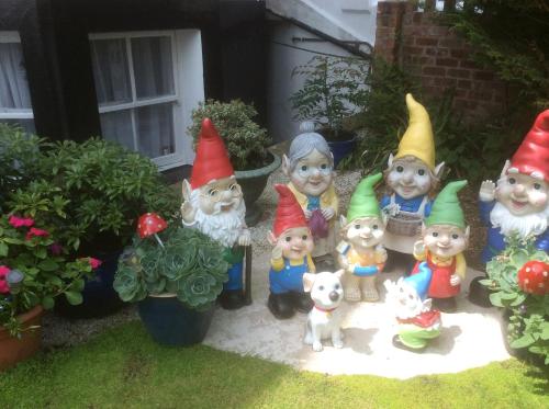 a group of gnomes in a garden with plants at Craig-Ard Hotel in Llandudno
