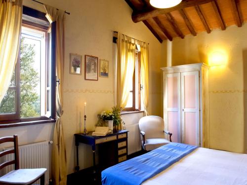 a bedroom with a bed and a desk and a window at Agriturismo Sant'illuminato in Calzolaro