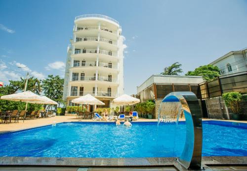 a swimming pool with two people in a hotel at Kobuleti Pearl Of Sea Hotel & Spa in Kobuleti