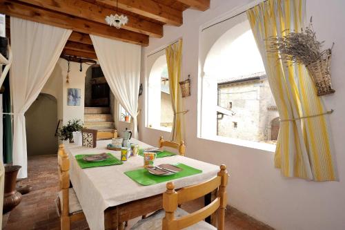 - une salle à manger avec une table et deux fenêtres dans l'établissement Loggia, à Vobarno