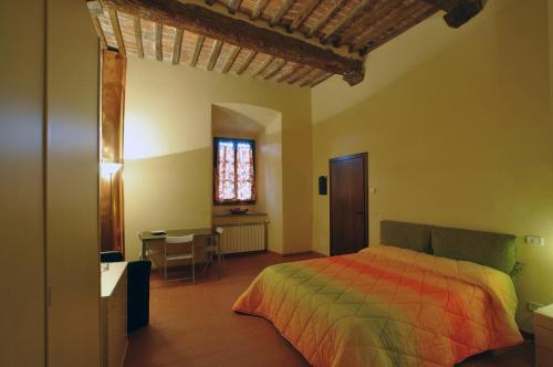 a bedroom with a bed and a table and a window at Terre Regionali Toscane in Alberese