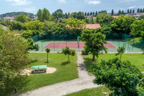 a park with two tennis courts and a bench at Hôtel Odalys Erromardie in Saint-Jean-de-Luz