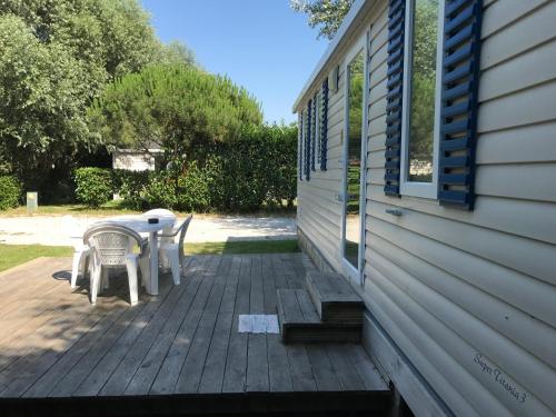 a patio with a table and chairs on the side of a house at Camping De Collignon in Cherbourg en Cotentin