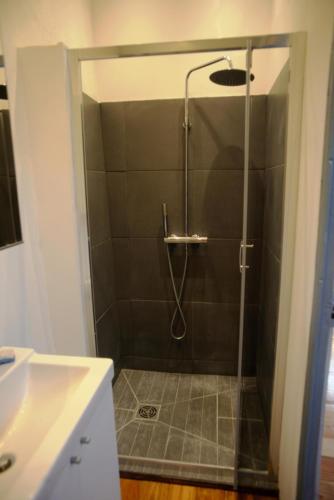 une douche avec une porte vitrée dans une salle de bain dans l'établissement Petit Balaguier, à La Seyne-sur-Mer