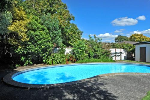 a large blue swimming pool in a yard at A'La Vista Motel in Palmerston North