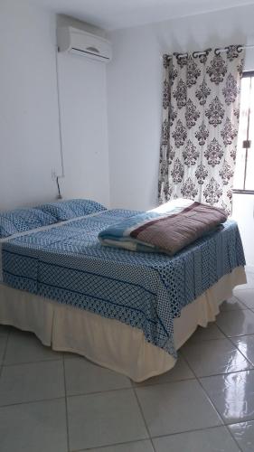 a bedroom with a bed with a blue blanket at Casa pousada ,Gravata Navegantes in Navegantes