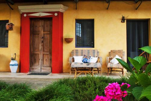 a house with two wicker chairs and a door at Lunafragola Atelier B&B in Candia Canavese