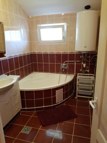 a bathroom with a tub and a sink at Nurmi House in Hajdúszoboszló