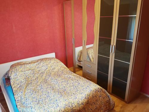 a bedroom with a bed and a glass cabinet at Nurmi House in Hajdúszoboszló