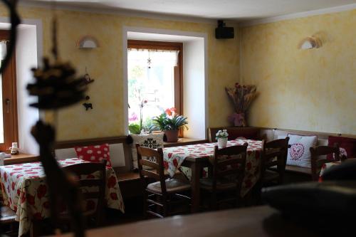 a dining room with tables and chairs and a window at Residence Pavou in Cogne