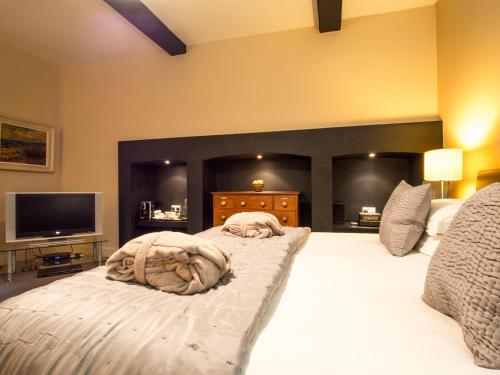 a bedroom with a large white bed with a flat screen tv at Six Brunton Place Guest House in Edinburgh