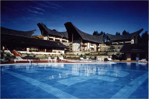 a large swimming pool in front of a large building at Hotel Sahid Toraja in Makale