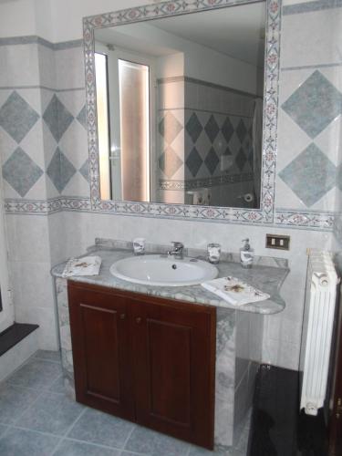 W łazience znajduje się umywalka i lustro. w obiekcie B&B del Mare w mieście Pozzuoli
