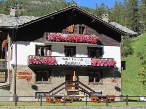 a building with flower boxes on the front of it at Hotel Lysjoch in Gressoney-la-Trinité