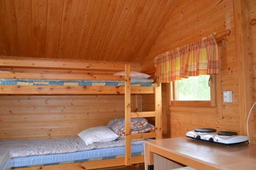 カリガスニエミにあるTenon Eräkievari mökitのログキャビン内のベッドルーム1室(二段ベッド2組付)