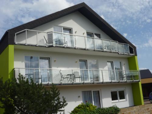 a building with balconies and tables and chairs on it at Gästehaus Deidesheim in Deidesheim