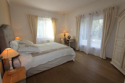 a bedroom with a bed and a large window at Aux charmes de grasse in Grasse