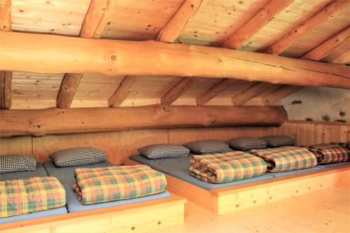 a room with four pillows on a bed in a cabin at Rifugio Alpe San Romerio in Brusio