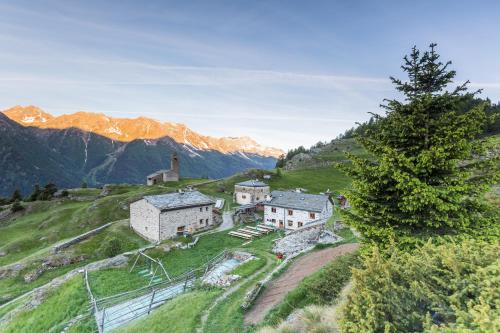 a village on a hill with mountains in the background at Rifugio Alpe San Romerio in Brusio