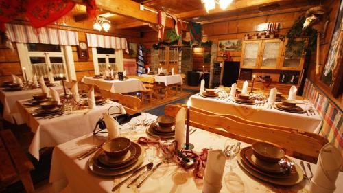 un ristorante con tavoli con tovaglie e piatti bianchi di Zrub Niki a Ždiar